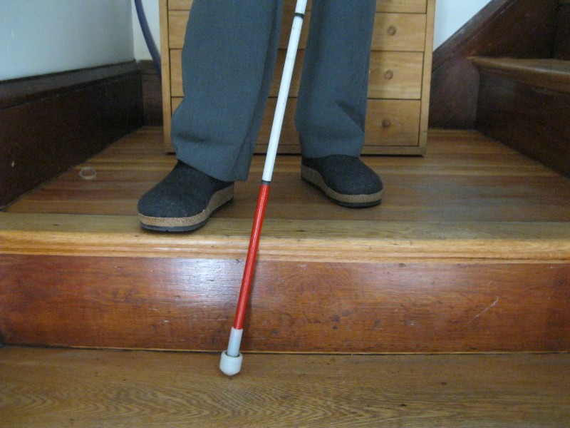 The white cane is out of the bag now. It is being used by someone walking downstairs. 