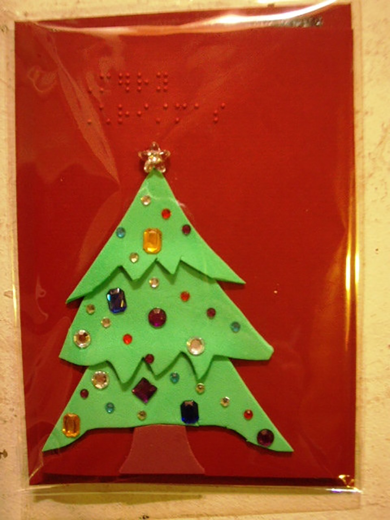 A Christmas tree on a red background from the collection of braille cards by Amber 